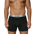 The image depicts the upper body of an athletic man that is wearing the black boxer shorts from the brand FRIEDENMEER, featuring a black 'FRIEDENMEER' text design on a white waistband, showcased and presented.