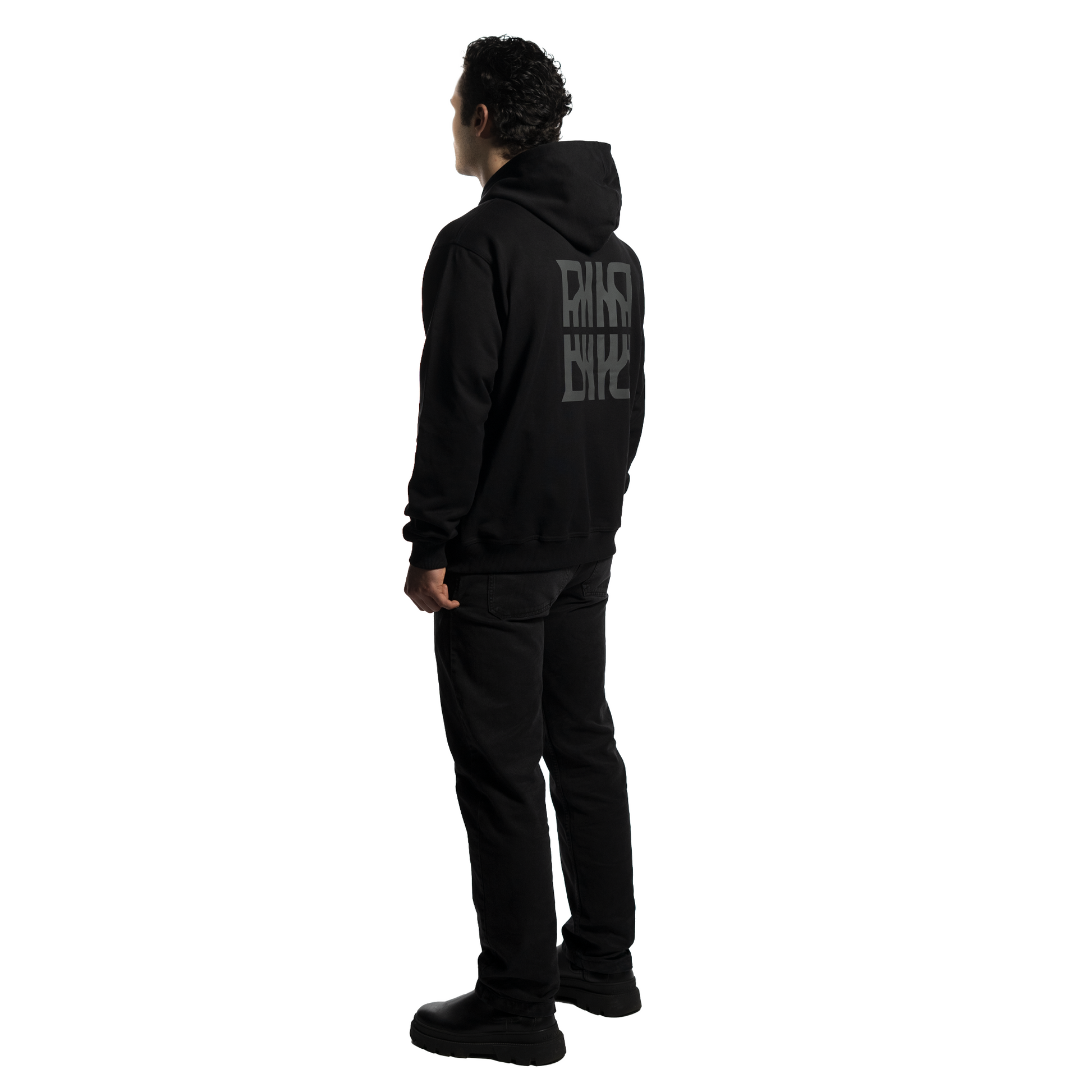 An elegant person wearing a luxurious black FRIEDENMEER zip up hoodie with a unique logo design, paired with stylish black trousers and modern shoes, showcasing high-end fashion.